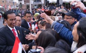 President Joko Widodo shakes hands with Indonesians welcoming him upon his arrival in the Netherlands.