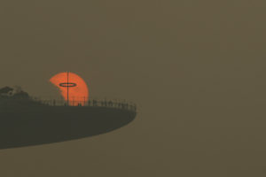 People watch the sun set from the observatory deck of the Marina Bay Sands hotel in Singapore  during haze session.