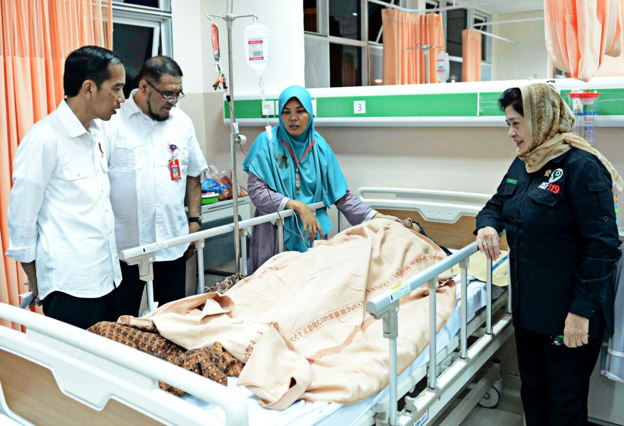 Accompanied by Health Minister Nila Moeloek (R), President Joko Widodo visits an earthquake victim at Dr. Zainoel Abidin Hospital in Banda Aceh on Thursday evening..
