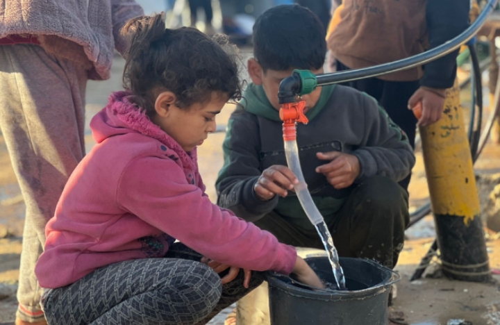 Two displaced Palestinian children fetching water in Rafah. (Photo: Mahmoud Ajjour, The Palestine Chronicle)