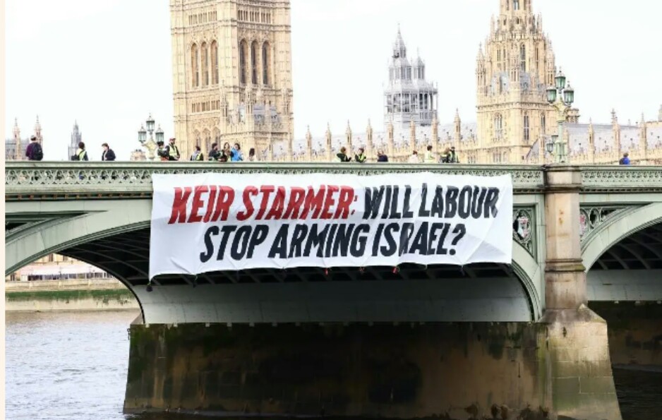 Activists drop a banner from Westminster Bridge, calling on Labor leader Keir Starmer to say he'll end arms sales to Israel if he becomes prime minister, on 3 June 2024, in London, Uk [Luca Marino]