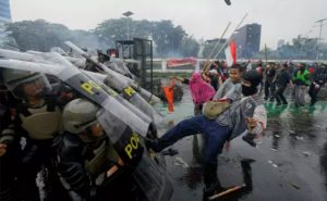 Protesters attack riot police members who shield themselves on Jalan Gatot Soebroto, in front of the parliament complex in Jakarta, Thursday, Aug. 28, 2025. (B-Universe Photo/Joanito De Saojoao)